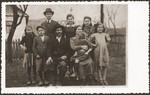 Group portrait of members of a Jewish family in the yard of their home in Volovec.