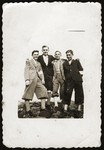 Portrait of four youths in the Dabrowa ghetto wearing armbands.