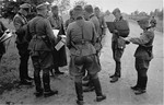 German officers in the field consult with their commanding officer on their orders of the day.
