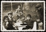 A group of Jewish children seated outside around a table.