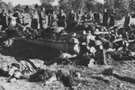 Soviet investigators in the Klooga concentration camp examine corpses stacked for burning.