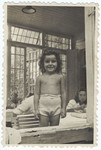 A young Jewish girl poses in her underwear in a summer colony outside of Warsaw where she has gone to recuperate after the war.