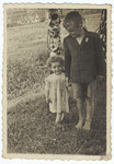A young Jewish girl in hiding walks in the field next to a an older peasant boy.