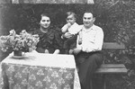 A Jewish couple sits outside with their son in Plonsk, Poland.