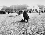 Jews are forced to sweep the pavement in the town square of Raciaz.