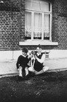 A Jewish child who is living in hiding poses with the son of his rescuers in front of their home in Dinant, Belgium.