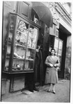 Jozsa Kovacs (later Taubner) stands next to her father Alexander Kovacs in front of the entrance to a store in Galanta.