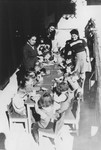 A kindergarten class sits around a table in the Feldafing displaced persons' camp.