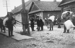 Jews in the Kovno ghetto carry furniture and large bundles.