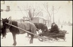 Dr. Leon Gordon drives to a house call on a horse drawn sleigh through a snowy street in Eisiskes.