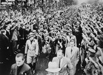 German civilians enthusiastically salute 440 Italian youth as they march through the streets of Berlin while on a state visit to Germany.