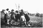 A group of teenagers dance a hora outside the Poulouzat children's home.