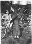 Herbert Karliner, a German Jewish refugee youth helps a younger refugee child, Charles Mandell, ride a bicycle in the Masgelier children's home.