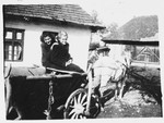 Two Jewish teenagers pose in a horse-drawn wagon in Bilki.