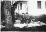Two young Jewish children sit outside in the snow in front of their house in Bilki.