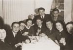 A group of Jewish friends gather in a private home for a farewell party for Rivka Radzinski prior to her departure for Palestine.