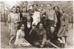 Jewish DPs pose around a cow in a  hachshara in Prebitz.