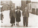 Mendel-Ajzik, Cesia, and Abram-Zelig Kleiner walk down a snow-covered street in Lazy, Poland.