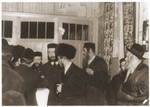 Ger Hasidim, including the rebbe, gather to greet  the bridegroom before a wedding.