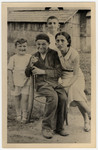 Portrait of four Jewish children and teenagers posing outside a wooden house in Drohobycz.