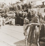 An elderly woman and her granddaughter, who have just arrived in Haifa on board the Mala immigrant ship, walk along the pier.