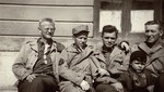 American soldiers in Dachau pose with a young survivor.