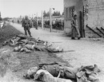 An American soldier stands beside the bodies of SS personnel shot by U.S.