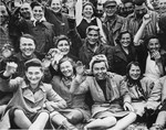 Liberated female prisoners at Dachau wave to their liberators.