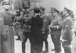 SS Major General Juergen Stroop (second from left) gathers information from a civilian on the second day of the suppression of the Warsaw ghetto uprising.