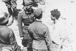 An SS Lieutenant (Untersturmfuehrer) interrogates a Jewish resistance fighter captured on the twenty-first day of the suppression of the Warsaw ghetto uprising.