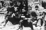 SS soldiers pause to eat during the suppression of the Warsaw ghetto uprising.