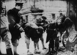 Young boys caught smuggling by a German soldier in the Warsaw Ghetto.