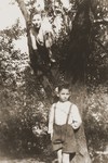 Two boys pose in a tree in the garden of the Jewish children's home in Gleiwitz, Poland.