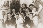 Friends and family pose with the bride and groom at a wedding celebration in the Bergen-Belsen displaced persons camp.