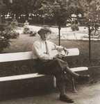 Aron Broda sits on a park bench in Katowice.