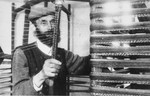 A Jewish man operates a loom in an unidentified ghetto.