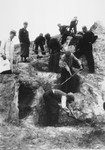 Jews dig trenches in the Lodz ghetto supervised by members of the Jewish police.