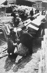 A group of Jewish men haul lumber through what probably is the Lodz ghetto.