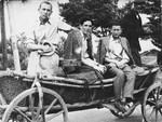 Zygmunt Godzinski (middle) sits with two friends on a horse-drawn wagon in Kielce.
