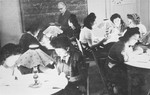 Young Jewish women living at the Le Tremplin children's home study in small groups seated around several tables.