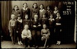 Fourth grade class picture. 

(first row) Avigdor Katz (left ) and Yankele Kaganovicz; (second row, right to left) Sheinele Dwilanski, (first name unknown)  Bichwid, Hayya Shlanski, Hebrew teacher Mr.