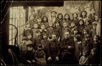 Young children and teachers pose for a studio school portrait.