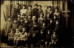 Elementary school class photo in Eisiskes.  

Seated in the center is the principal Moshe Yaakov Botwinik.