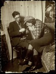 A Jewish teenager lights a cigarette for his girlfriend in her room in Eisiskes.