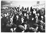A crowd of Jewish DP men, women, and children attend a meeting in a hall in the Schlachtensee displaced persons camp.