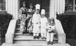 The Feist children pose on the steps of their home, dressed in Purim costumes.