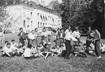 Jewish DP youth who numbered among the Buchenwald children, listen to a boy play the violin while sitting on the lawn at the Chateau d'Ambloy children's home in France, operated by the OSE (Oeuvre de Secours aux Enfants).