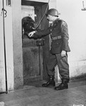 At the prison in Nuremberg, Pfc. Joseph L. Pichierre guards the door to the cell of Rudolf Hess, a defendant at the International Military Tribunal trial of war criminals.