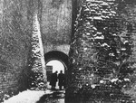 Two men walk through the archway on the Ku Farze alley in Lublin.