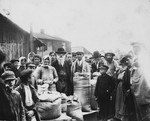 Group portrait of a Jewish family standing in front of the their grains stall in the Drohobycz marketplace.